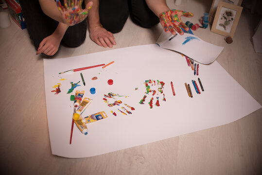 Two lovers draw with paints. Two lovers draw with paints. Hands are covered with paint .