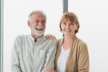 Portrait of senior elderly couple smiling with happiness in modern living room