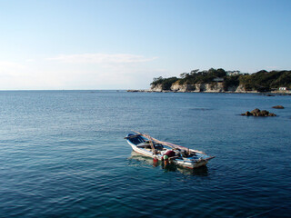 Japanese local fisherman, hooking shellfish like awabi, uni, seaweed, from the bottom of the sea.　箱眼鏡で貝や海藻を獲る漁師船の風景写真