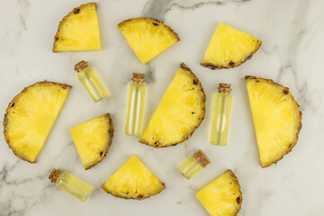 cosmetic background. slices of ripe juicy pineapple and bottles with a cork lie on a marble surface. the concept of natural cosmetics.