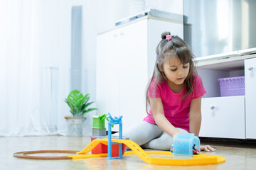 baby game. Little clever caucasian child playing colorful toy railway and train for early development.