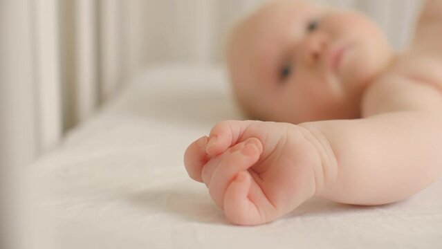 Close up hand of cute little child lying on bed relaxing having calmness emotion