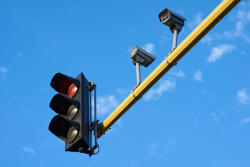 Low angle shot of traffic light and cameras on a pole