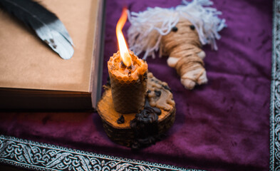 Illustration for esoteric contents, scene with a candle and book of spells , esoteric concept, fortune telling, other magic stuff on a table	
