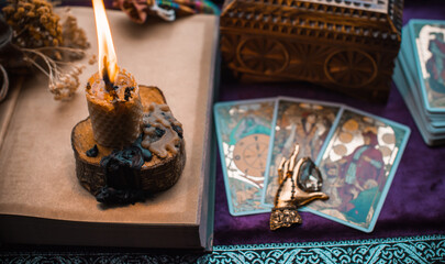 Illustration for esoteric contents, scene with a candle and book of spells , esoteric concept, fortune telling, other magic stuff on a table	
