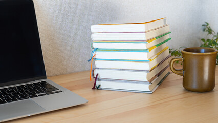 机上の本とノートパソコン