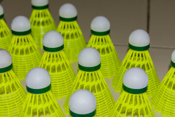 Nylon made yellow color badminton shuttlecock close view looking awesome placed on floor in different position. - 483740485