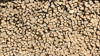 Big wall off chopped firewood in hush sunlight. As a pattern