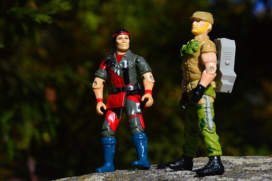 GI JOE Hasbro action figures of native american Spirit from year 1984 and Rock N Roll with ammo backpack from year 1989 standing on rock in autumn afternoon sunshine. 