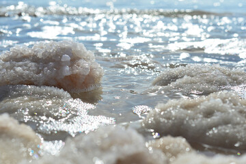 Obraz na płótnie Canvas Close up of salt background. Natural salt. Dead Sea salt mineral natural formations. Salt crystals from Dead sea. View of Dead Sea coastline. Texture of Dead sea. Salty seashore rocks