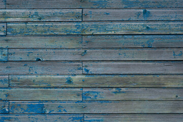 Vintage wood background. Old weathered wooden plank painted in blue color. Boards with cracked and peeling paint. Old painted wood wall - texture or background.