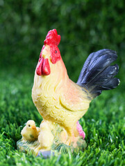 Toy cock with chicks on the grass © sabdiz