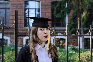 Cute teenage graduate girl laughing and having fun. No school, back to school concept. Graduation. Education.	