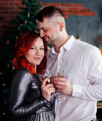 charming couple with glasses of champagne in the New Year's interior