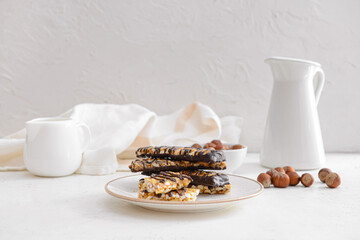 Plate with tasty chocolate nut bars on table