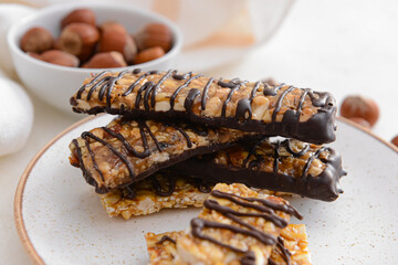 Plate with tasty chocolate nut bars on table, closeup