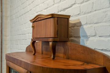 an old wooden sideboard against a white brick wall. Restoration of old furniture. Handmade repair of home furniture.