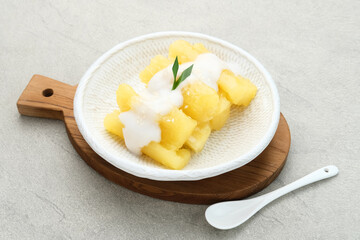 Singkong thailand, sweet cassava, made of boiled cassava, sugar and coconut milk. Served in bowl and pandan leaf, selective focus.
