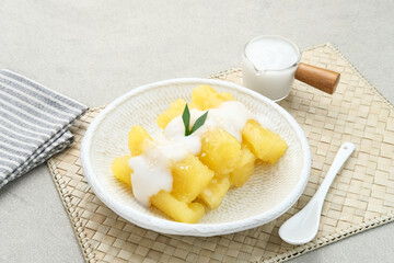 Singkong thailand, sweet cassava, made of boiled cassava, sugar and coconut milk. Served in bowl and pandan leaf, selective focus.
