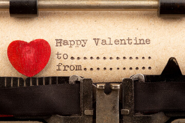 Happy Valentine - phrase on typewriter. Valentines Day greetings concept. Little red wooden heart...