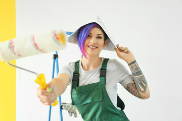 Female painter with roller near color wall