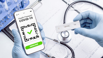 Coronavirus passport doctor holding. Covid vaccination certificate or vaccine passport on smartphone screen with doctor stethoscope, syringe and medical equipment on hospital white background.