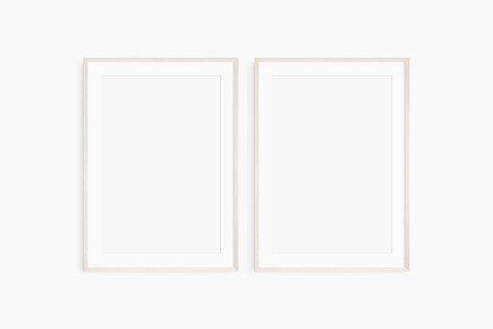 Frame mockup 5x7, 50x70, A4, A3, A2, A1. Set of two thin light wood frames. Gallery wall mockup, set of 2 frames. Clean, modern, minimalist, bright. Portrait. Vertical. Mat opening 2:3.