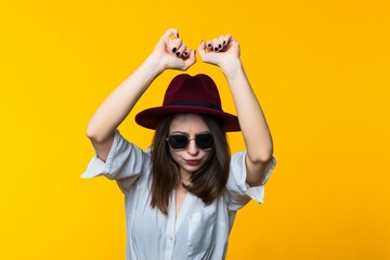 Young woman dancing on yellow background