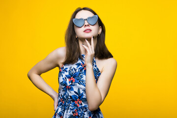 Naklejka premium A young woman in a dress and sunglasses