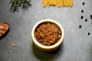 Italian food ingredients for spaghetti bolognese. Raw spaghetti pasta with various ingredient on gray background. Top view