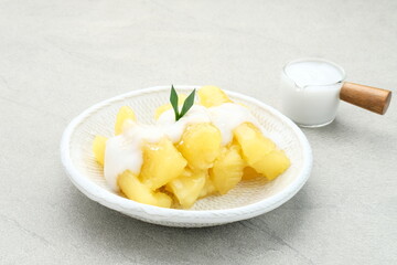 Singkong thailand, sweet cassava, made of boiled cassava, sugar and coconut milk. Served in bowl and pandan leaf, selective focus.
