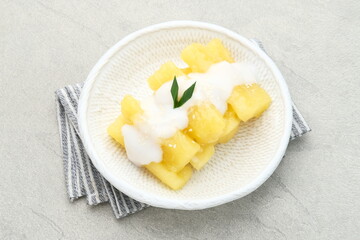 Singkong thailand, sweet cassava, made of boiled cassava, sugar and coconut milk. Served in bowl and pandan leaf, selective focus.
