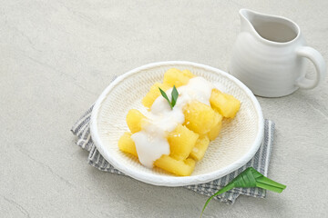 Singkong thailand, sweet cassava, made of boiled cassava, sugar and coconut milk. Served in bowl and pandan leaf, selective focus.
