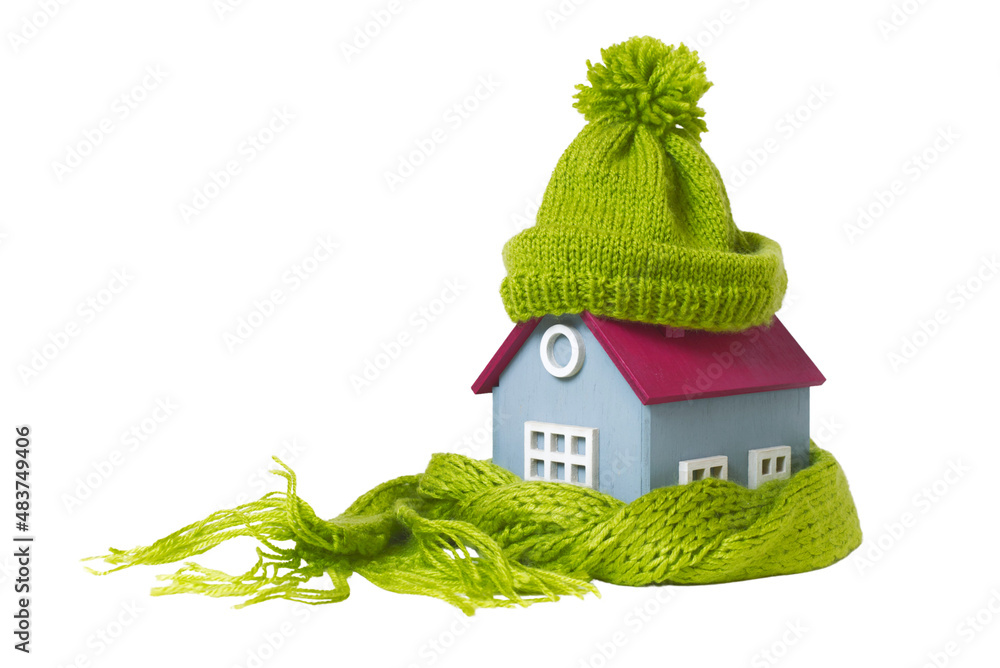 Wall mural house in a warm knitted green cap and a scarf