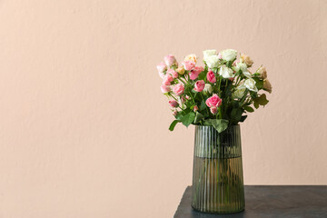 Vase with bouquet of beautiful roses on table