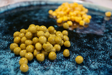 green pea and corn on a beautiful glazed plate on the wooden table