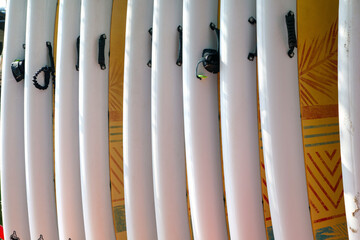 Yellow sup surf boards lined up in a rack
