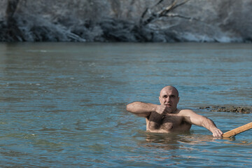 A man is baptized and preparing to plunge into the freezing river in winter on the feast of Epiphany. Russia Krasnodar Territory, Armavir 09.18.2021