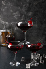 Glasses of tasty Manhattan cocktail on black background