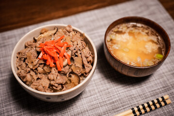 Japanese lunch set of a bowl of popular Japanese food Gyudon served with pickled ginger (beef and onions in a bowl on rice), and a bowl of traditional soup Miso