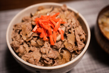 A bowl of popular Japanese food Gyudon served with pickled ginger (beef and onions in a bowl on rice)