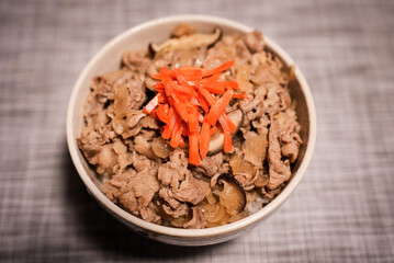 A bowl of popular Japanese food Gyudon served with pickled ginger (beef and onions in a bowl on rice) 