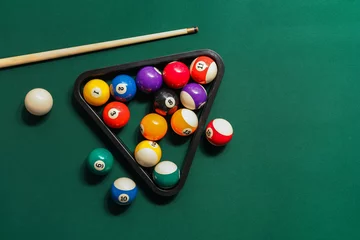 Foto op Plexiglas Verschillende biljartballen met keu en rek op groene tafel © Pixel-Shot