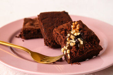 Plate with pieces of tasty chocolate brownie on white background