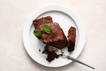 Plate with pieces of tasty chocolate brownie on white background