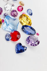 A scattering of precious stones on a light background, close-up.