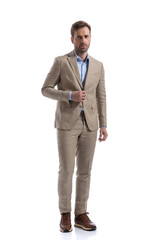 attractive businessman opening his jacket, looking at the camera