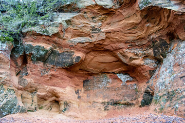 Red sandstone outcrop with caves in autumn