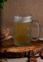 Refrescante caneca de vidro com cerveja para uma tarde de verão sobre uma madeira redonda