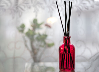 Still life with red vase with brown sticks in it